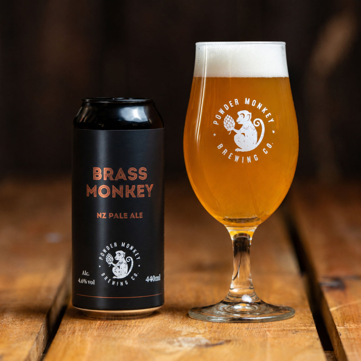 A black can of Brass Monkey NZ Pale Ale stands next to a glass filled with beer