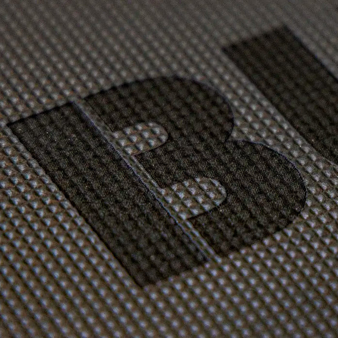 Close-up of a dark textured surface with large black letters on a gray Cushion