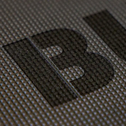 Close-up of a dark textured surface with large black letters on a gray Cushion