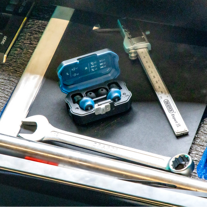 DXPULSE Noise Isolating Earbuds with Charging Case next to a wrench and ruler