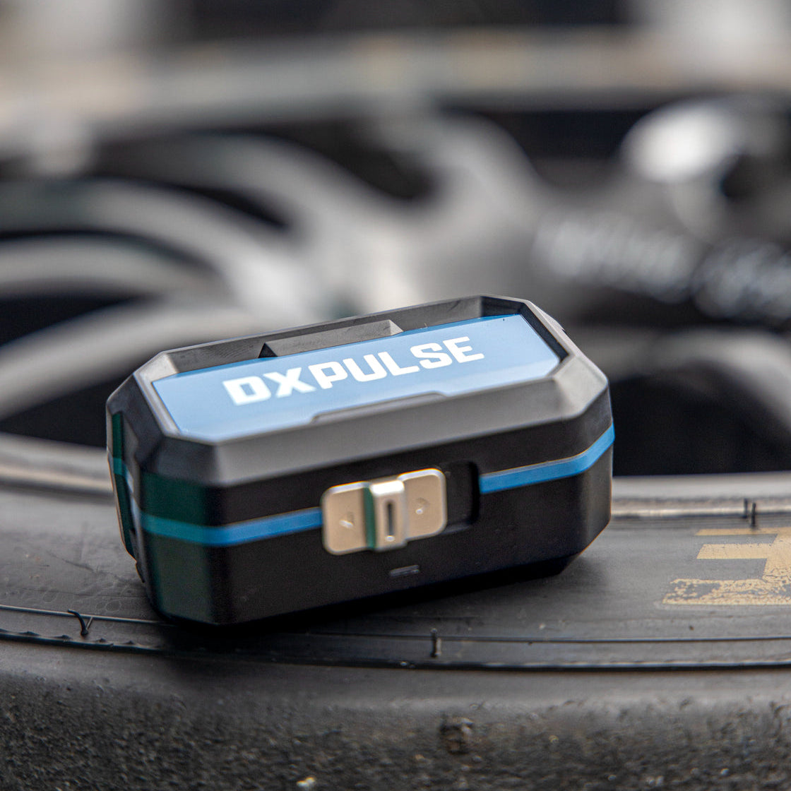 Closed DXPULSE Noise Isolating Earbuds with Charging Case on a tyre