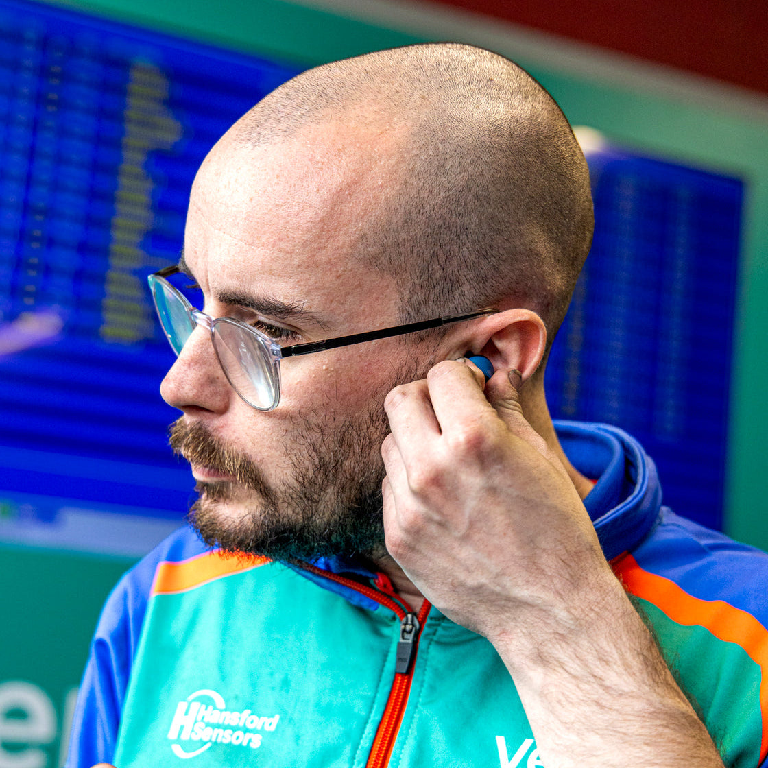 Man putting in the DXPULSE Noise Isolating Earbuds