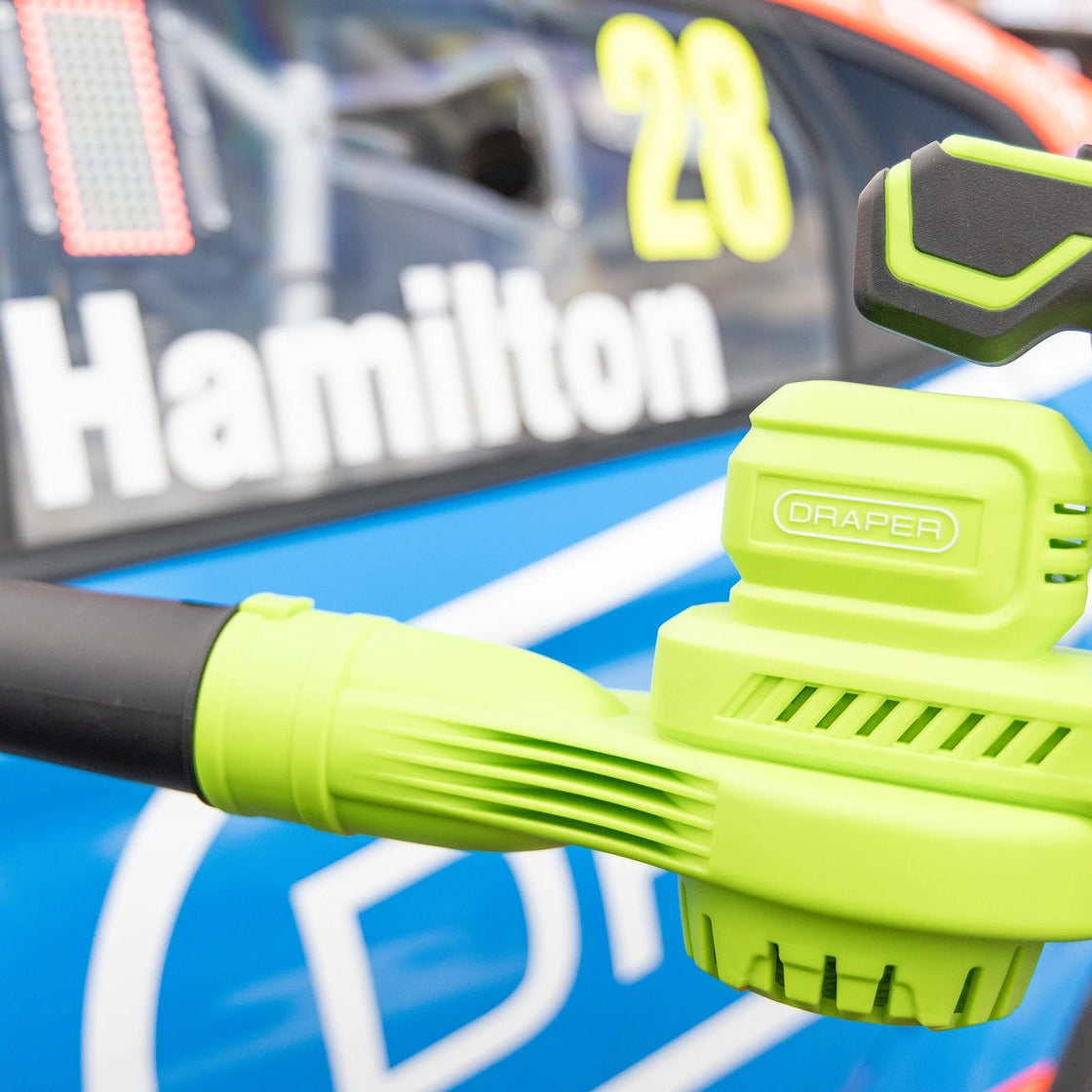 A close-up of a Grapen electric leaf blower with a bright lime green body and black hose
