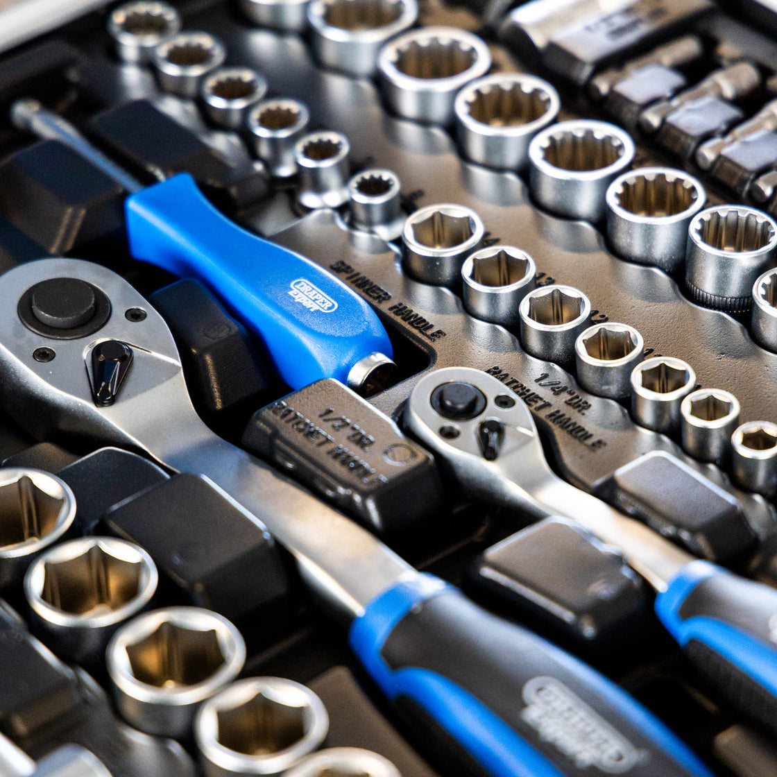 A close-up of a socket wrench and socket set with silver metal sockets, ratchets, and sockets 