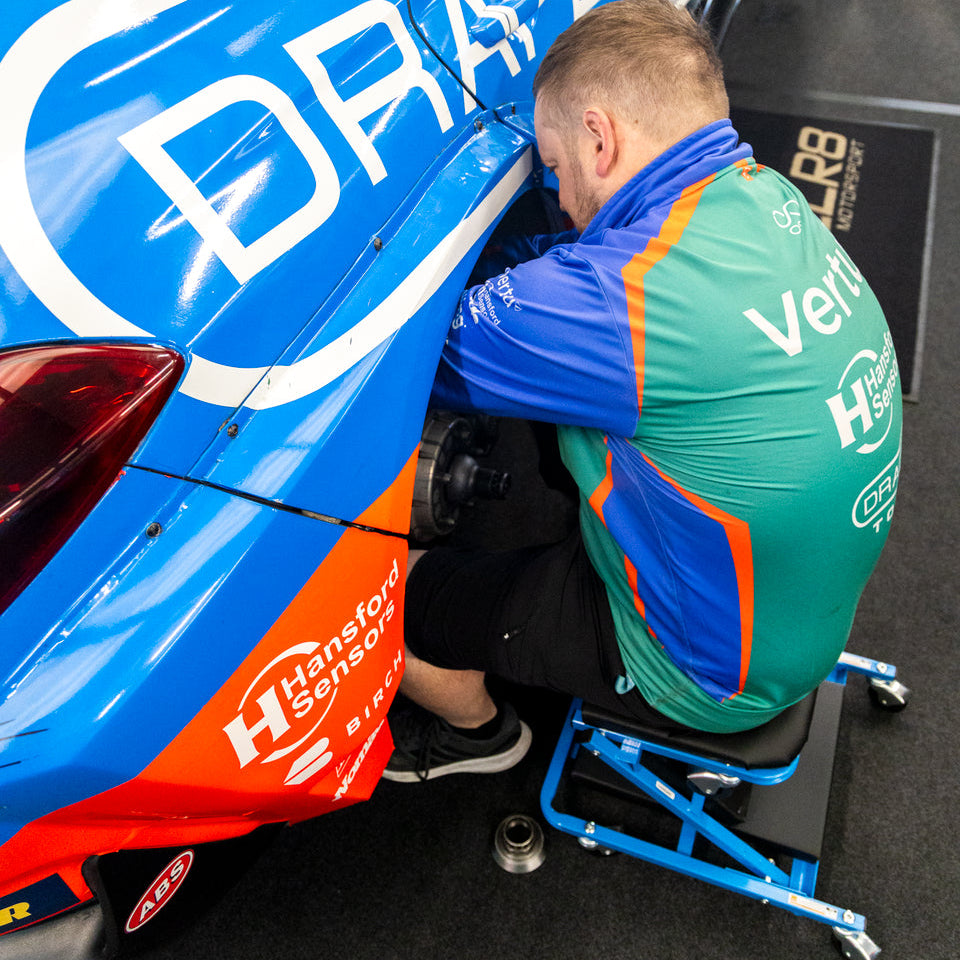 A race team mechanic fixing the car on the Car Creeper & Seat by Draper tools