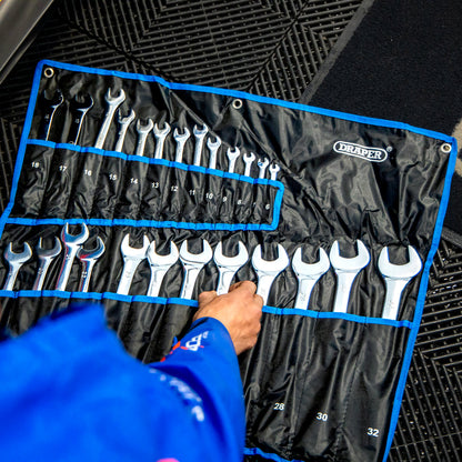 A person in a blue work race jacket grabbing a spanner from the Draper HI-TORQ® Metric Combination Spanner Set