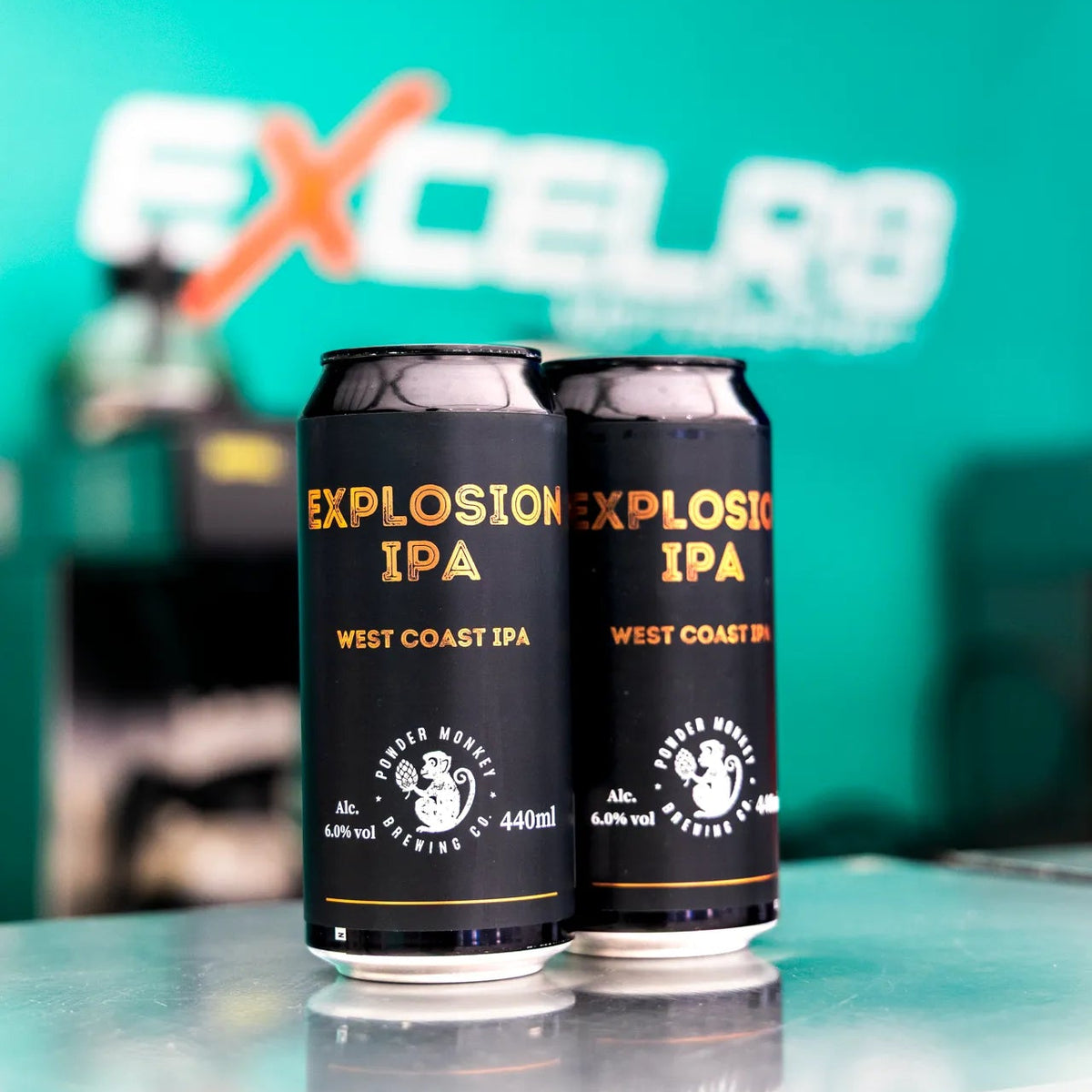 Two black cans of Explosion IPA West Coast IPA beer are standing on a reflective surface