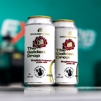 Two cans of Champions The Golden Drop English-hopped pale ale are standing on a reflective surface