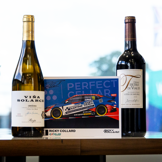 Two wine bottles and a branded display card arranged on a tabletop in a bright indoor setting. The left bottle is a pale green glass bottle labeled VIVA SOLARI, the right bottle is a dark red wine bottle with a label starting with FF, and the center card reads PERFECT CELAR and features a race car with Ricky Collard branding.